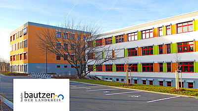 Modernes, buntes Schulgebäude mit Parkplatz im Landkreis Bautzen.
