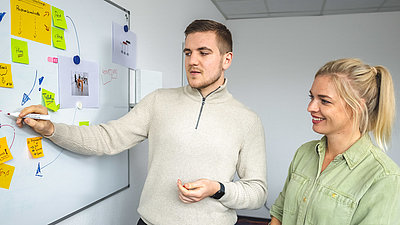 Zwei Studenten arbeiten am Whiteboard zusammen