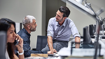 Employees talking at a desk