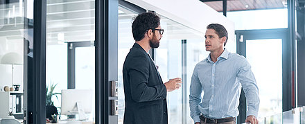 Zwei Security-Experten beraten sich auf Galerie eines gläsernen Büros
